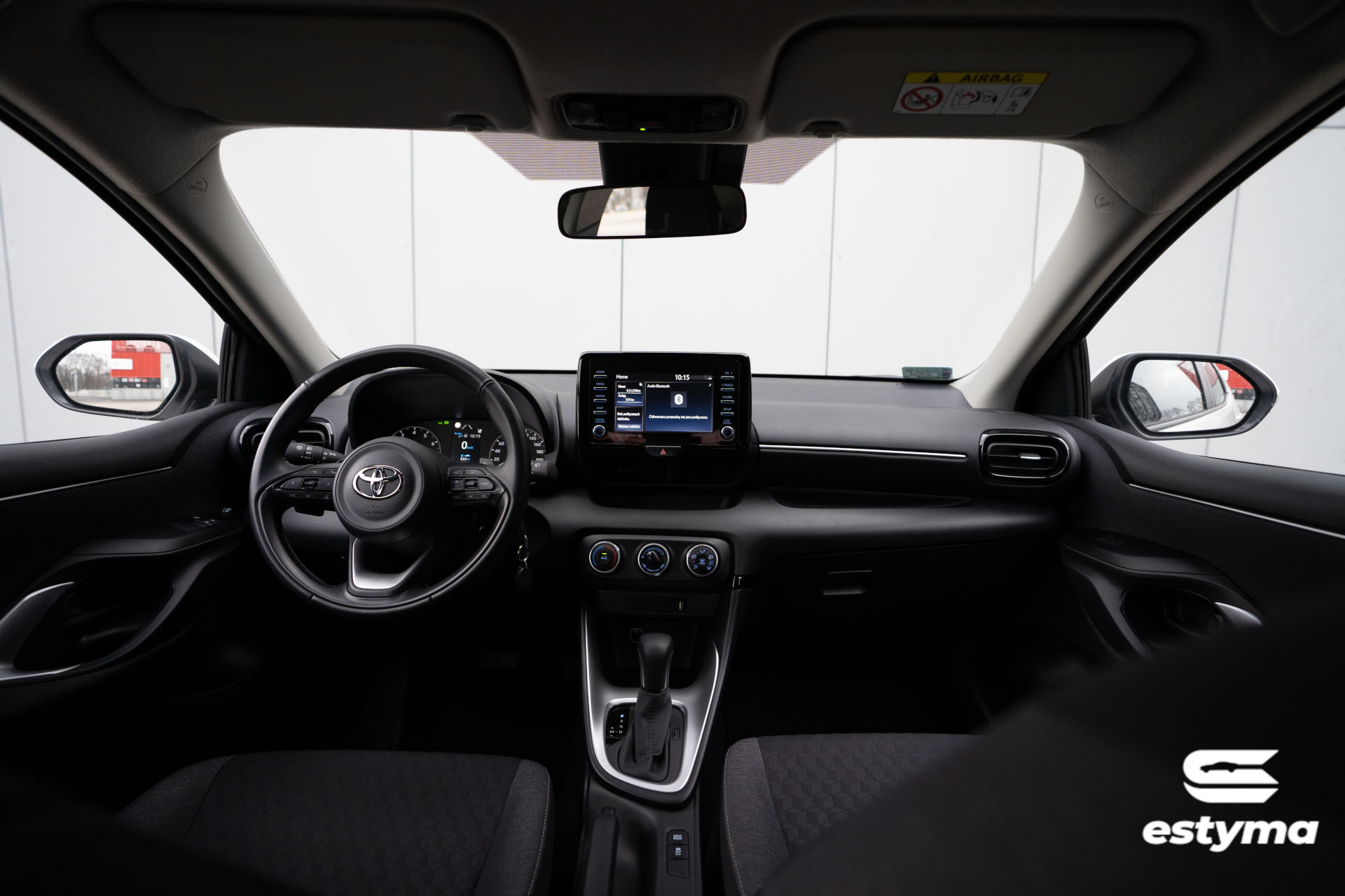 Toyota Yaris IV, widok wnętrza z perspektywy tylnego pasażera. Dostępna na wynajem w wypożyczalni samochodów.