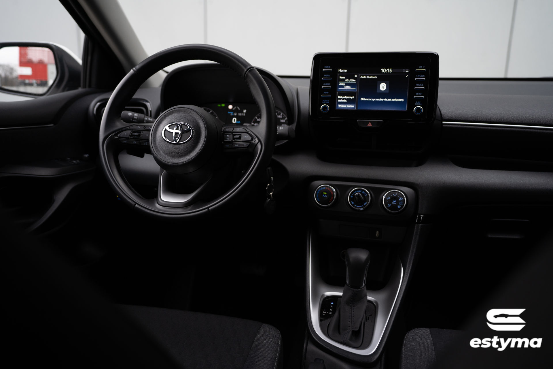Toyota Yaris IV, panel kierowcy z perspektywy tylnego pasażera. Dostępna na wynajem w wypożyczalni samochodów.